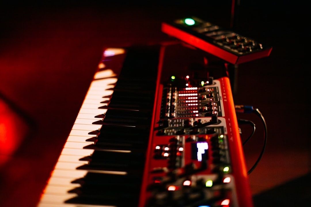 Elektronisk synthesizer med tangenter och lysande reglage i rött ljus