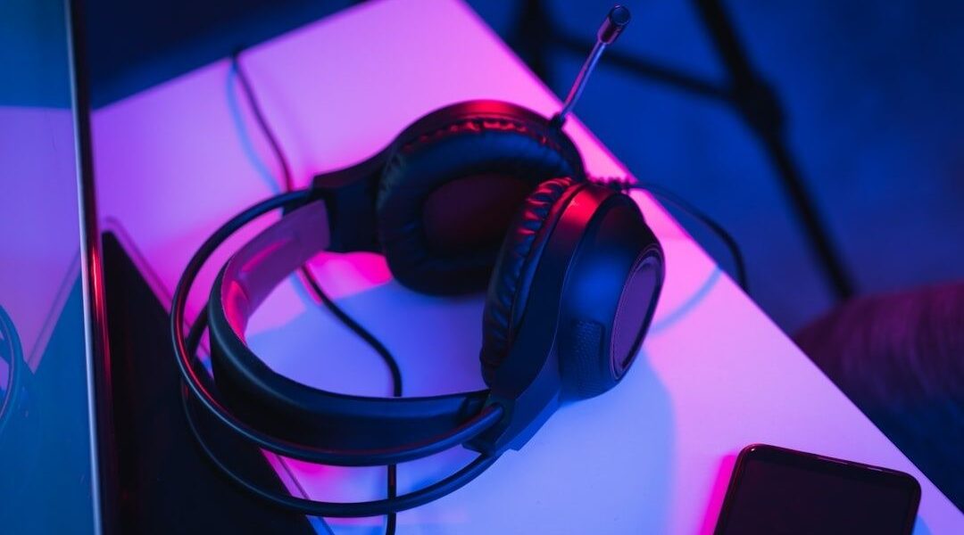 Gamingheadset med mikrofon på ett neonupplyst skrivbord