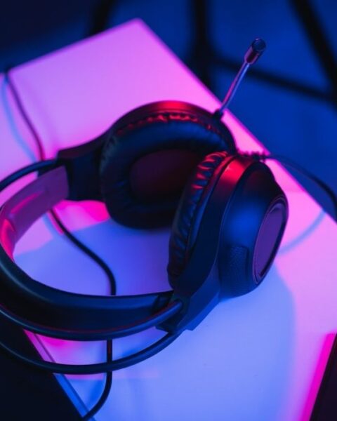 Gamingheadset med mikrofon på ett neonupplyst skrivbord