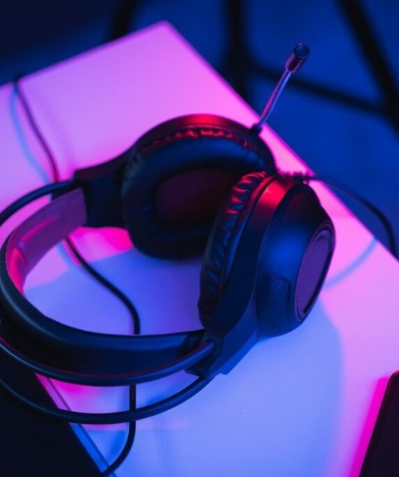 Gamingheadset med mikrofon på ett neonupplyst skrivbord