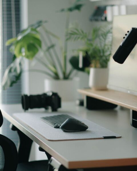 Ergonomisk datorarbetsplats med kontorsstol, skärm, mus och mikrofon
