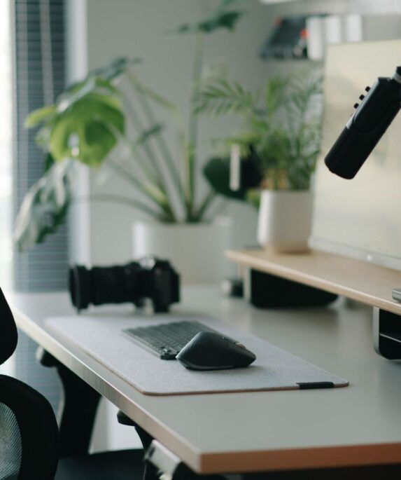 Ergonomisk datorarbetsplats med kontorsstol, skärm, mus och mikrofon